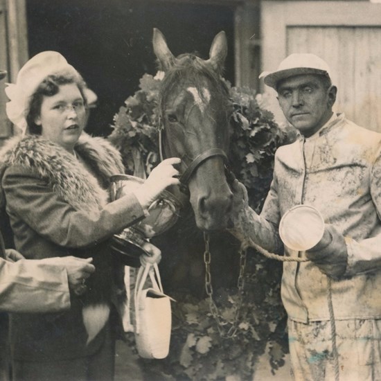 Travtræner Poul Stripp med pokalen i hånden efter Jollys sejr i Dansk Trav Derby 1948. Han flankeres af de tre ejere - f.v. slagtermester Børge Johansen og frue samt benzinforhandler Karl Götke.